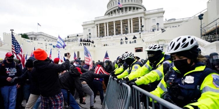 Trump supporters try to break through a police barrier, Wednesday, Jan. 6, 2021, at the Capitol in Washington. As Congress prepares to affirm President-elect Joe Biden's victory, thousands of people have gathered to show their support for President Donald Trump and his claims of election fraud. (AP Photo/Julio Cortez)