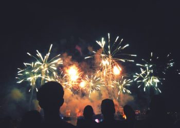 Crowd of Silhouetted People Watching a Colorful Fireworks Display for New Years or Fourth of July Celebration Event, Horizontal, Copy Space