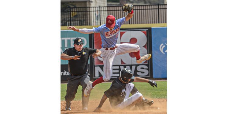 Independence shortstop Michael McKinney  jumps above North Marion runner Bryce Rhoades who slides in safely with a double during Class AA State Tournament action in Charleston. (F. Brian Ferguson/Lootpress)
