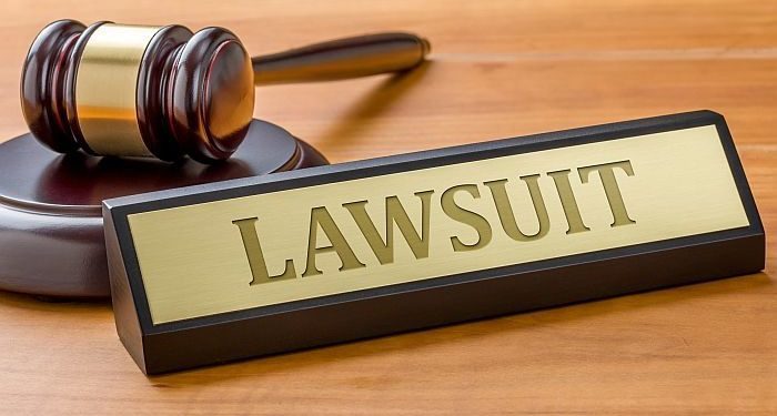 A gavel and a name plate with the engraving Lawsuit