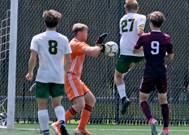 (Brad Davis/For LootPress) Woodrow Wilson goalkeeper Josh Farnsworth knocks down a mid-air scoring attempt from Brooke's Eddie Marks (#27) Saturday afternoon at the YMCA Paul Cline Memorial Sports Complex.