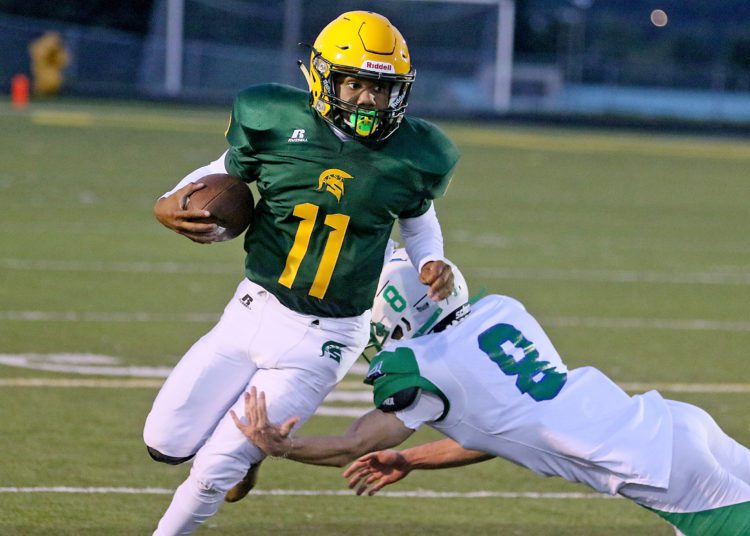 (Brad Davis/For LootPress) Greenbrier East quarterback Monquelle Davis gets past Robert C. Byrd defender Jaidan Willis Sept. 10 in Fairlea.
