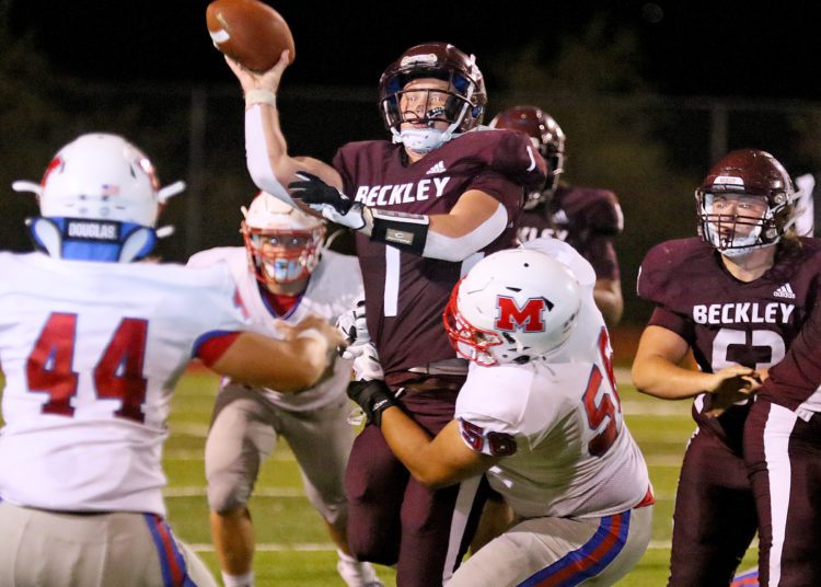 (Brad Davis/For LootPress) Woodrow Wilson's Maddex McMillen gets a throw off as he's hit by Morgantown defender Braylon Brown Friday night in Beckley.