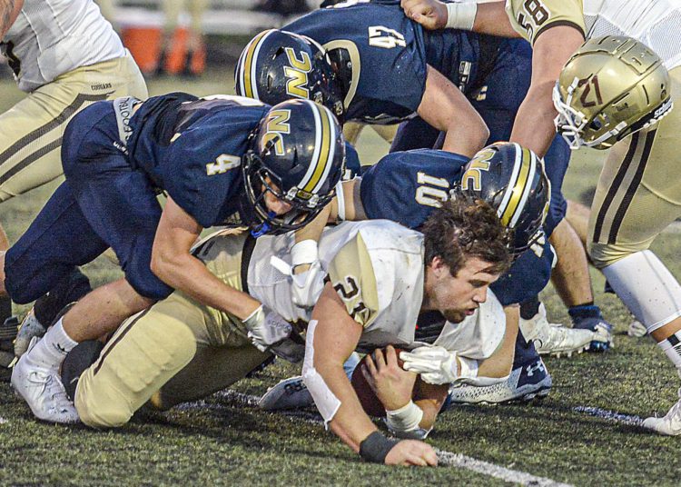 Nicholas County’s Alex Pritt, Gavin Blankenship, and Kaleb Clark dislodge the helmet of the Lincoln RB during Thursday evening action in Summersville. (F. Brian Ferguson/Lootpress).