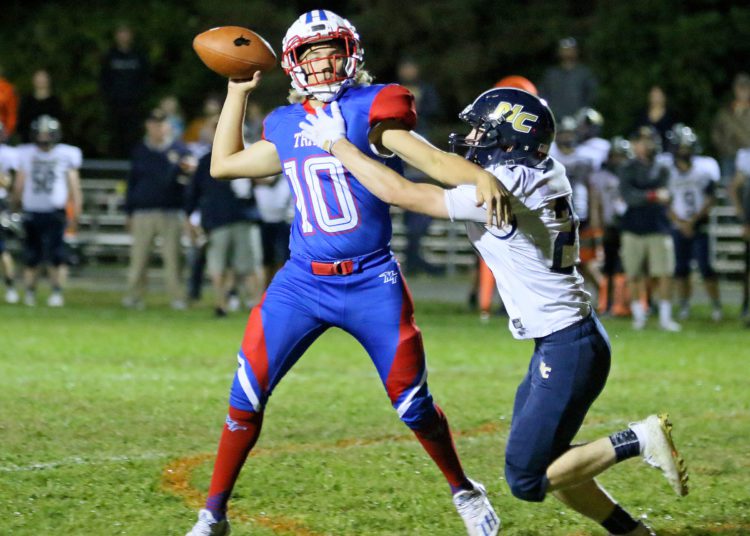 (Brad Davis/For LootPress) Nicholas County's Wes Hill gets to Midland Trail quarterback Joshua Dickerson as he tries to throw Friday night in Hico.