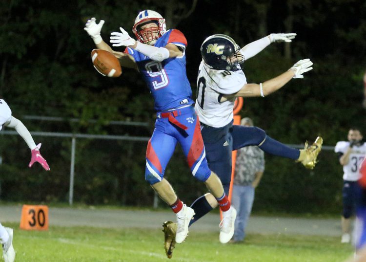 (Brad Davis/For LootPress) Midland Trail receiver Cody Harrell and Nicholas County defender Kaleb Clark both leap for a pass Friday night in Hico.