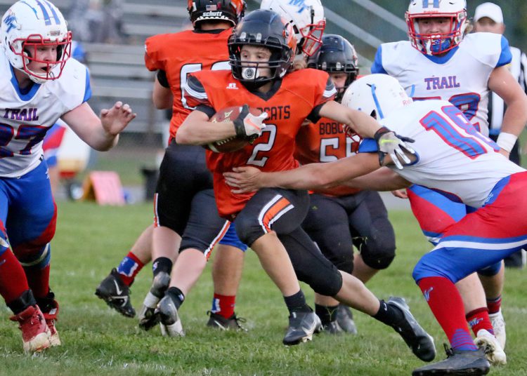 (Brad Davis/For LootPress) Summers County's Drake Cole carries the ball as Midland Trail's Zane Burford, right, reaches out to tackle him Monday night in Hinton.