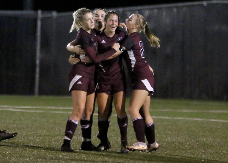 (Brad Davis/For LootPress) Woodrow Wilson's Mya Wooton, middle, is hugged by teammates after scoring her second goal of the game Thursday night in Beckley.