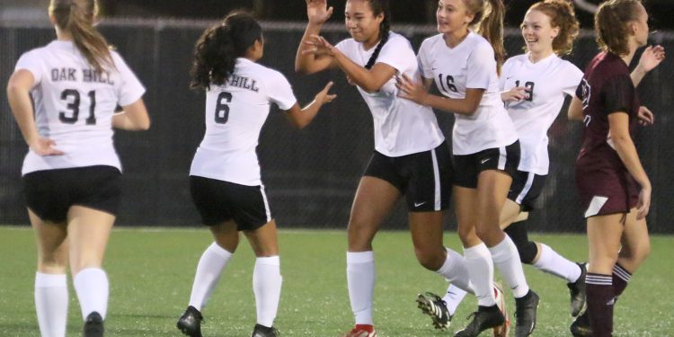 (Brad Davis/For LootPress) Oak Hill's Samiah Lynch, middle, is congratulated by teammates after scoring the game's opening goal against Woodrow Wilson last season in Beckley.