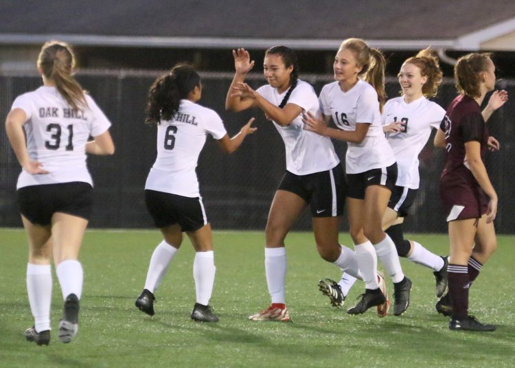 (Brad Davis/For LootPress) Oak Hill's Samiah Lynch, middle, is congratulated by teammates after scoring the game's opening goal against Woodrow Wilson last season in Beckley.