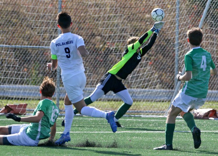 (Brad Davis/For LootPress) Charleston Catholic goalkeep Ethan Bastin makes a critical save on Fairmont Senior's Bubby Towns (#9) in relief of injured starter John Patnoe during State Soccer Tournament action Friday morning in Beckley.