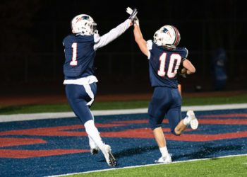 Independence's Trey Bowers (left) and Judah Price (right) high five after Price scores on a punt return Nov. 12 in Coal City. (Heather Belcher/Lootpress)