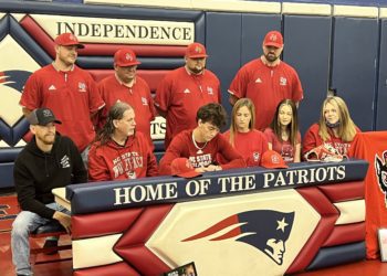 Michael McKinney, surrounded by coaches and family, signs his letter of intent to play college baseball at N.C. State Wednesday at Independence High School.