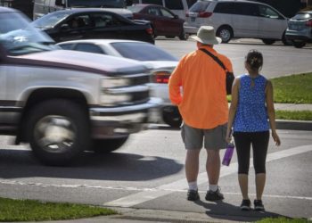 FILE - In this June 8, 2016, file photo, a maroon and silver truck drove, left, drives through the marked crosswalk in front of pedestrian volunteers Dave Passiuk and Nelsie Yang in St. Paul, Minn. Drivers of bigger vehicles such as pickup trucks and SUVs are more likely to hit pedestrians while making turns than drivers of cars, according to a new study. The research released Thursday, March 17, 2022, by the Insurance Institute for Highway Safety points to the increasing popularity of larger vehicles as a possible factor in rising pedestrian deaths on U.S. roads. (Glen Stubbe/Star Tribune via AP, File)