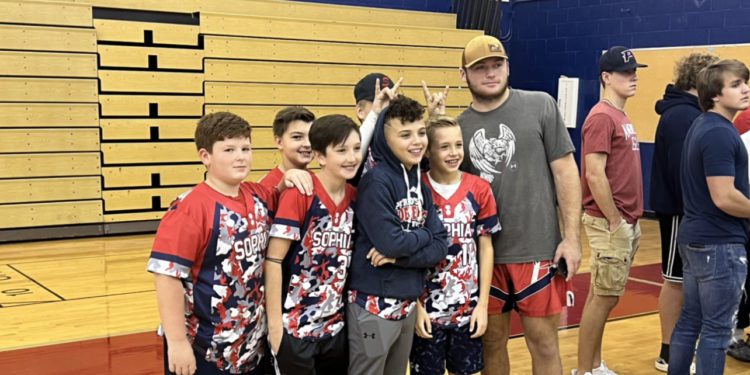Independence graduate Atticus Goodson takes a picture with several little leaguers during a signing for teammate Michael McKinney in November.