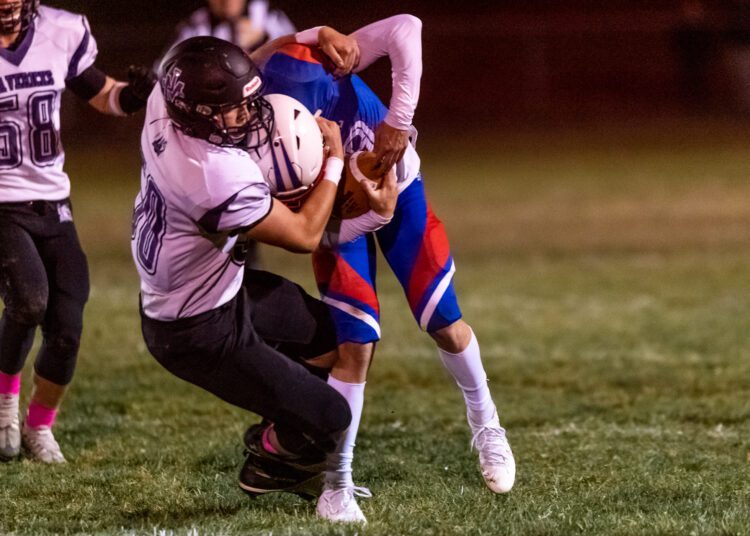Ball carrier for Midland Trail, Cody Harrell, tackled by #50 for James Monroe, Jackson Phipps