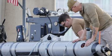 Members of the Navy work on a device on a vessel along the InterCoastal Waterway in North Myrtle Beach, S.C., Tuesday, Feb. 7, 2023. Using underwater drones, warships and inflatable vessels, the Navy is carrying out an extensive operation to gather all of the pieces of the massive Chinese spy balloon a U.S. fighter jet shot down off the coast of South Carolina on Saturday. (AP Photo/Nell Redmond)