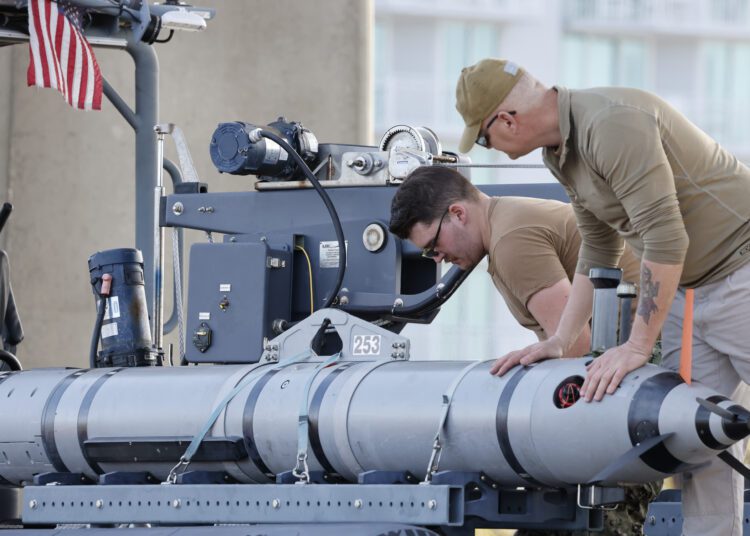 Members of the Navy work on a device on a vessel along the InterCoastal Waterway in North Myrtle Beach, S.C., Tuesday, Feb. 7, 2023. Using underwater drones, warships and inflatable vessels, the Navy is carrying out an extensive operation to gather all of the pieces of the massive Chinese spy balloon a U.S. fighter jet shot down off the coast of South Carolina on Saturday. (AP Photo/Nell Redmond)