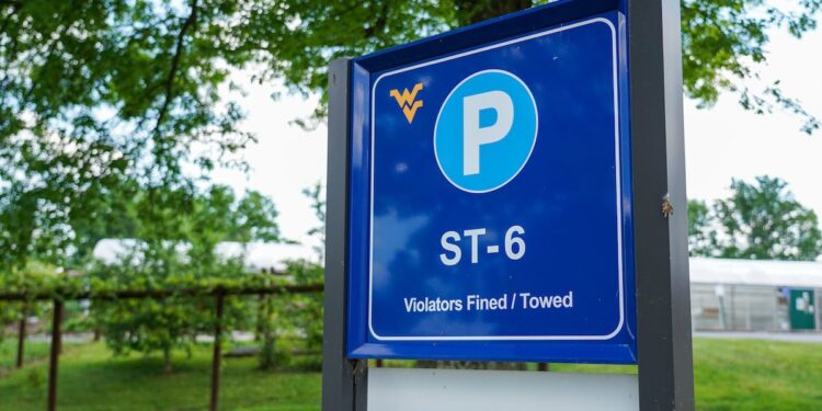 A short-term parking sign stands near a parking lot on the Evansdale area of campus, June 5, 2021. Photo: Morgan Goff.