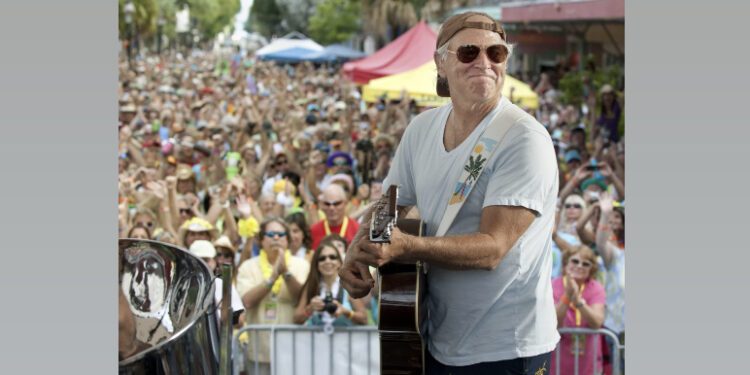 In this Nov. 4, 2011, file photo released by the Florida Keys News Bureau, singer/songwriter Jimmy Buffett performs before fans on Duval Street in Key West, Fla. Buffett, who popularized beach bum soft rock with the escapist Caribbean-flavored song “Margaritaville” and turned that celebration of loafing into an empire of restaurants, resorts and frozen concoctions, has died, Friday, Sept. 1, 2023. (Rob O’Neal/Florida Keys News Bureau via AP)