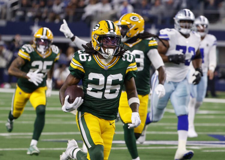 Green Bay Packers safety Darnell Savage (26) runs with the ball after making an interception on a pass by Dallas Cowboys quarterback Dak Prescott during the first half of an NFL football game, Sunday, Jan. 14, 2024, in Arlington, Texas. Savage scored on the interception return. (AP Photo/Michael Ainsworth)