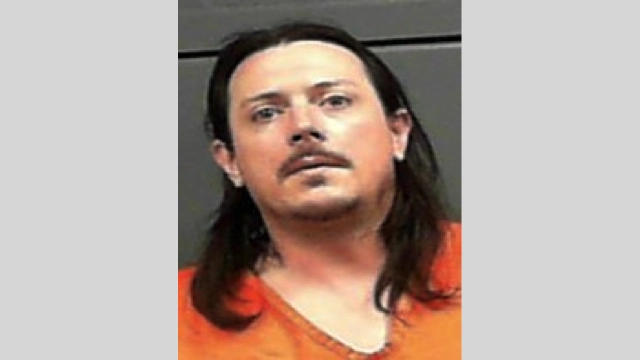 A man was charged after he threw water on his girlfriend and then struck her with a mop.