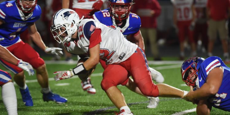 Independence's Sylas Nelson (12) carries the ball as Hoover's Mighty Lopez (right) grabs his ankle and Hoover's MyKell Taylor (4) and Hayden Payne (12) help make the stop during their game played at Hoover Thursday, Aug. 29, 2024.  (Chris Dorst | Gazette-Mail)