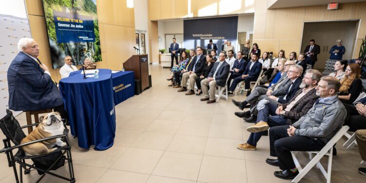 Gov. Jim Justice speaks alongside his dog, Babydog, during a ceremonial bill signing event Monday (Oct. 28) at the WVU Rockefeller Neuroscience Institute. (WVU Photo/Brian Persinger)