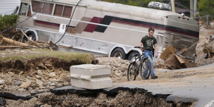 Dominick Gucciardo walks to his home in the aftermath of Hurricane Helene, Thursday, Oct. 3, 2024, in Pensacola, N.C. (AP Photo/Mike Stewart)