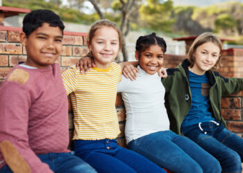 Shot of a group of children hanging out together outside on school grounds