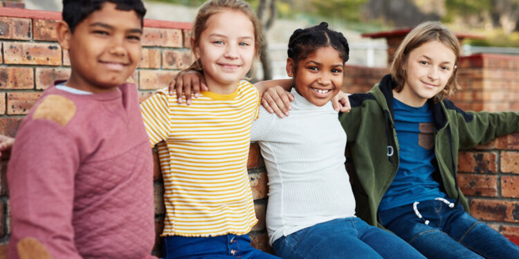 Shot of a group of children hanging out together outside on school grounds